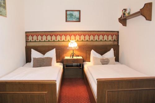 um quarto com duas camas e uma mesa com um candeeiro em Schneck Apartments em Schönau am Königssee