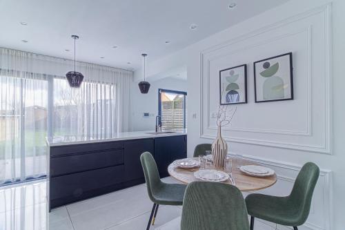 une salle à manger avec une table et des chaises vertes dans l'établissement Les Nénuphars - Piscine et salle de sport équipée, à Dunkerque