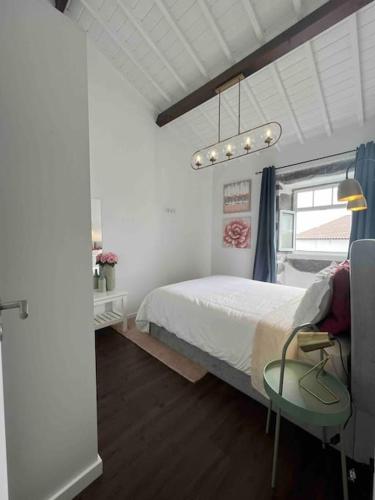 a bedroom with a bed and a table in it at Vento do Nordeste - Cottage with Jacuzzi in Nordeste