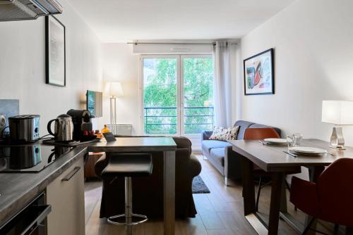 cocina y sala de estar con mesa y sofá en Lille Centre - Superb bright apartment parking en Lille