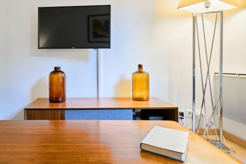 2 bouteilles assises au-dessus d'une table avec une télévision dans l'établissement Lille Centre - Superb bright apartment parking, à Lille