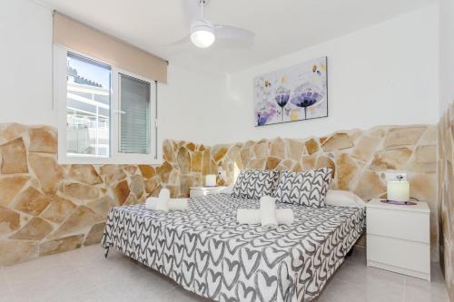 um quarto com uma cama e uma parede de pedra em Cala en Forcat em Cala en Forcat