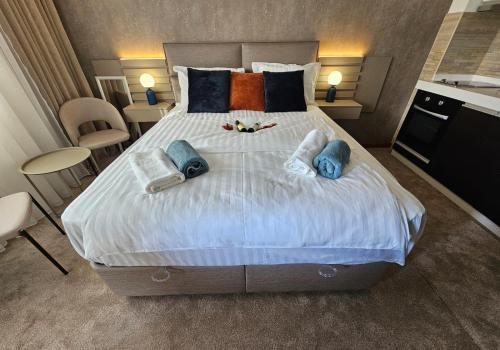 um quarto com uma cama grande com almofadas em AGAPE Apartment em Podgorica