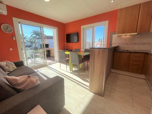 uma cozinha e sala de estar com um sofá e uma mesa em Apart-rent Apartment Bahia 0012 em Empuriabrava