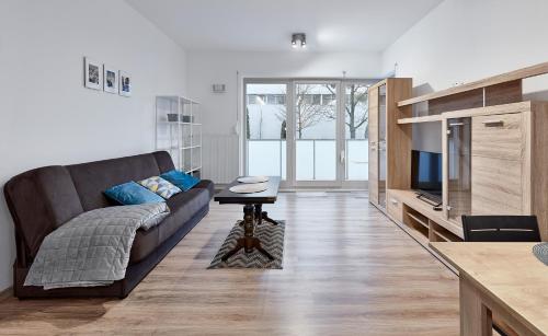 Zawady Comfort Apartment في بوزنان: غرفة معيشة مع أريكة وطاولة