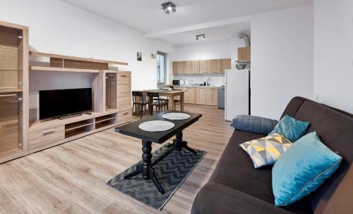 Zawady Comfort Apartment في بوزنان: غرفة معيشة مع أريكة وطاولة