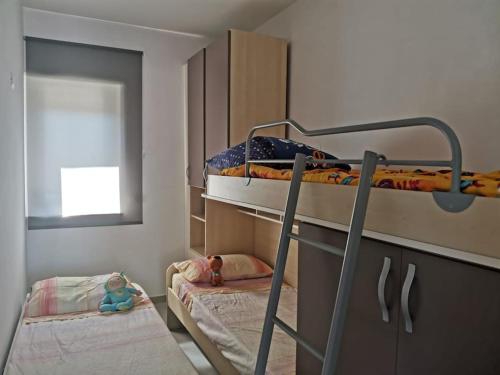 a bedroom with two bunk beds and a window at Zambrone Mare Appartamento / Piscina / Mare in Zambrone