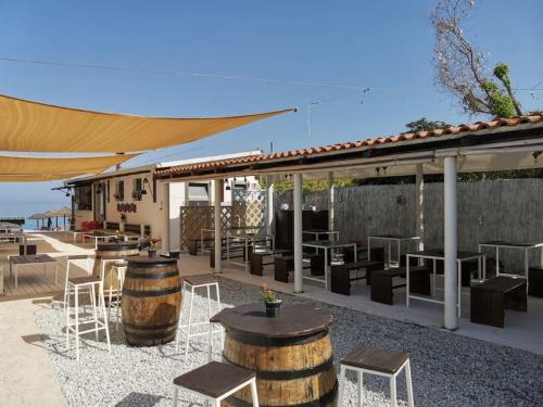 a patio with tables and chairs and a building at Zambrone Mare Appartamento / Piscina / Mare in Zambrone