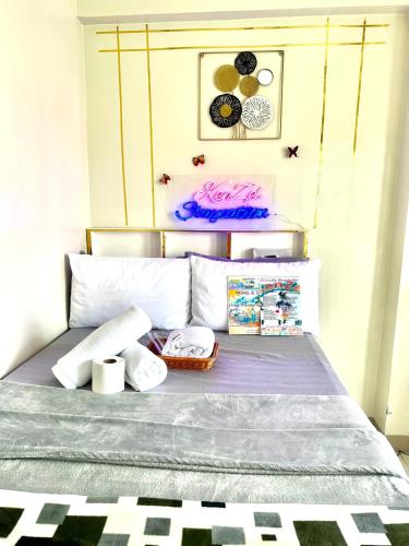 1 cama con 2 almohadas y toallas en KenZel Staycation, en Manila