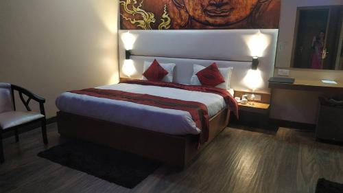 1 dormitorio con 1 cama grande con almohadas rojas en Hotel the Mansion , Mathura en Mathura