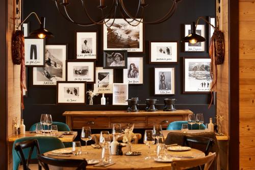 a restaurant with tables and chairs and pictures on the wall at Hôtel L'Arboisie in Megève