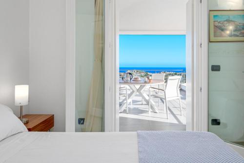 1 dormitorio con cama y vistas al océano en Villa Marconi Apartment 12 attico, en Golfo Aranci