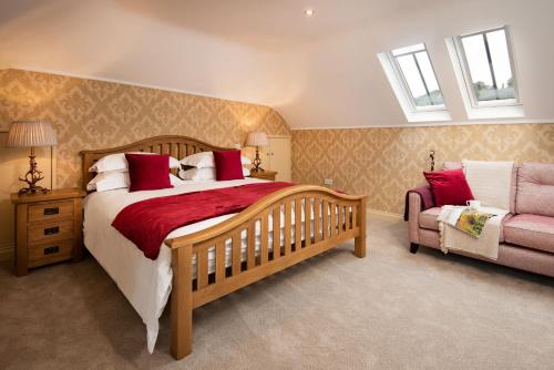 a bedroom with a large bed and a chair at Dryburgh Steading One in Saint Boswells