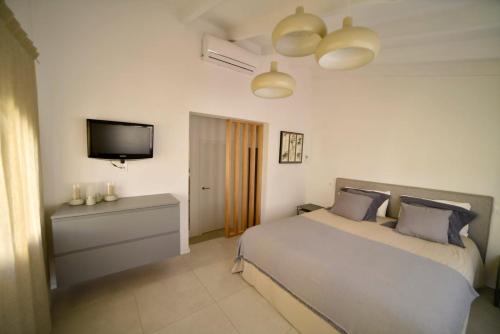 a bedroom with a bed and a flat screen tv at CASABLANCA in Jávea