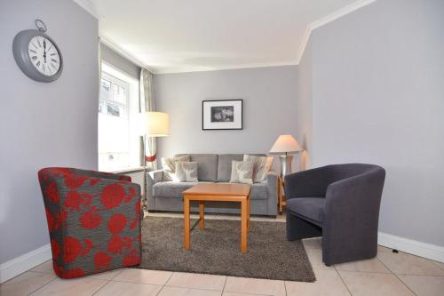 ein Wohnzimmer mit einem Sofa, einem Tisch und Stühlen in der Unterkunft Olympia Haus 4, Whg 34 in Westerland