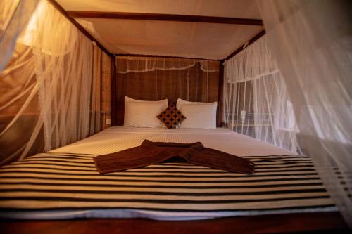 a bedroom with a bed with a robe on it at INN On The Tree Eco Resort Sigiriya in Sigiriya