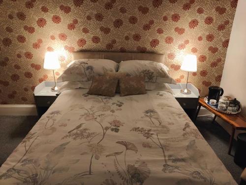 トーキーにあるGarway Lodge Guest Houseのベッドルーム1室(大型ベッド1台、ランプ2つ付)