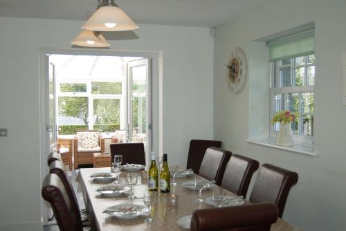 a dining room with a table with wine bottles and chairs at Glan yr Afon in Dolgellau in Dolgellau