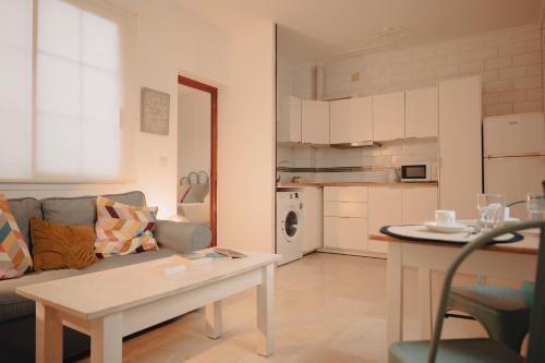 salon z kanapą i stołem w obiekcie Triana, cozy y con una ubicación ideal w Sewilli
