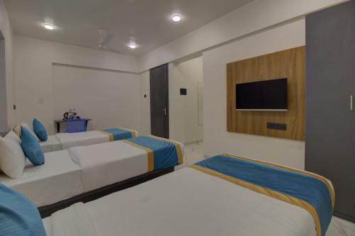 1 dormitorio con 2 camas y TV en la pared en 9 Bedroom Villa with Open Garden ALL ROOMS ATTACHED, en Pune