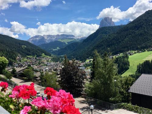 a view of a town in the mountains with flowers at B&B Lavi Ortisei val Gardena in Ortisei