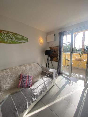 un salon avec un canapé et une porte coulissante en verre dans l'établissement La Ciotat vue mer emplacement exceptionnel avec parking, à La Ciotat