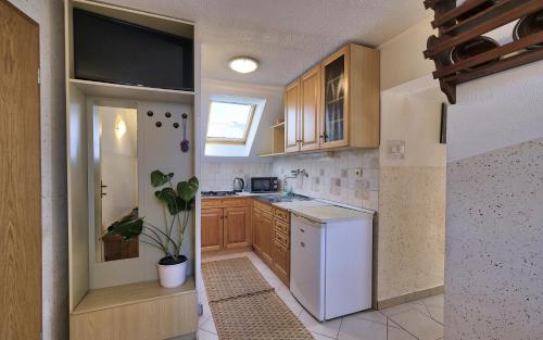 a kitchen with a white refrigerator and wooden cabinets at Apartmaji JOŠT in Bohinj