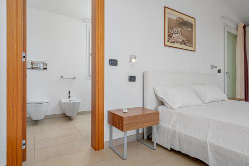 1 dormitorio con 1 cama y baño con bañera en Villa Marconi Apartment 12a attico, en Golfo Aranci