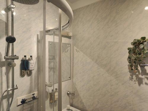 a shower with a glass door in a bathroom at Garway Lodge Guest House in Torquay