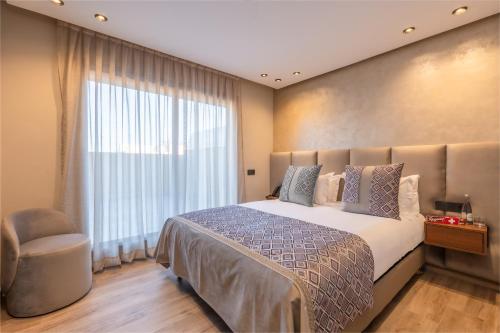 a bedroom with a large bed and a large window at SWISS CONTINENTAL HOTEL And SPA in Marrakesh