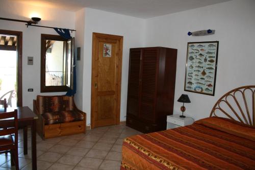 ポルト・オッティオルにあるPorto Ottiolu Resortのベッドルーム1室(ベッド1台、椅子、テーブル付)