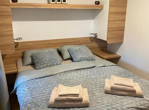 een slaapkamer met een bed met twee handdoeken erop bij Oliva Mobile Home in Biograd na Moru