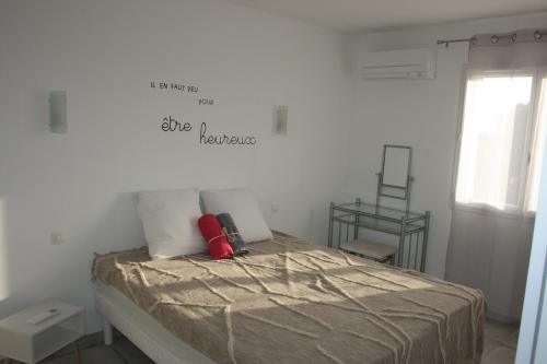 Ce lit se trouve dans une chambre blanche dotée d'un panneau mural. dans l'établissement Gite du Llevan, à Sorède