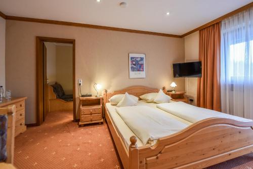 a bedroom with a large bed and a television at Landhaus Preißinger in Warmensteinach