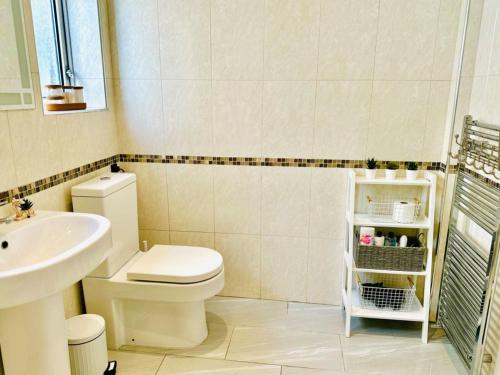 a bathroom with a toilet and a sink at 5 bedroom detached house sleeps 13 spacious Parking 5 mins driving to Bicester Village in Bicester