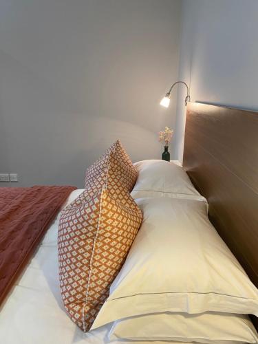 a bed with two pillows and a lamp on it at Belgravia Apartments in London