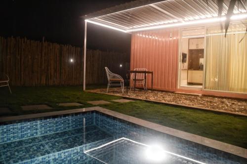 a backyard with a swimming pool at night at Clapping Leaves Resort in Hyderabad
