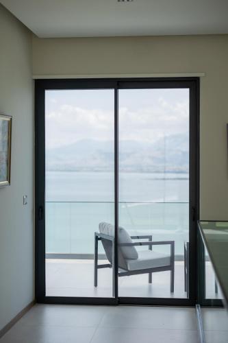 a room with a sliding glass door with a chair at The Luxury Villa in Široka