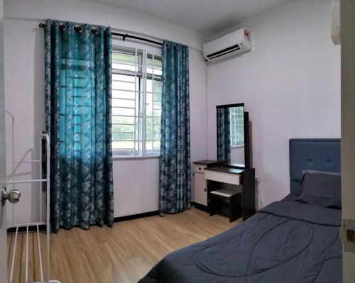 a bedroom with a bed and a window and a desk at Homestay @Seri Sindang Guesthouse in Kota Samarahan