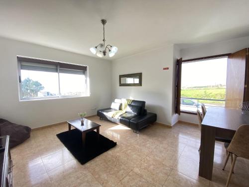 Luz's Retreat Apartment في بونتا ديلغادا: غرفة معيشة مع أريكة وطاولة