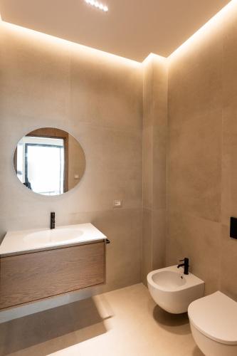 a bathroom with a sink and a toilet and a mirror at The Luxury Villa in Široka