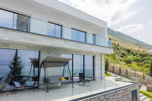 a house with a balcony with a view of the ocean at The Luxury Villa in Široka