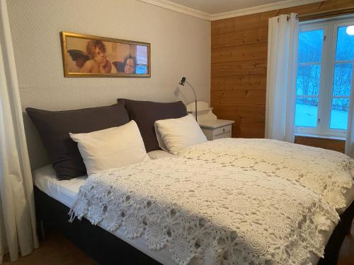 1 dormitorio con 1 cama con edredón blanco en Overvoll Farm, en Stranda