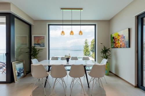 a dining room with a white table and chairs and a large window at The Luxury Villa in Široka