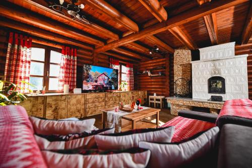 a living room with couches and a fireplace and a television at Rönkház Noszvaj in Noszvaj