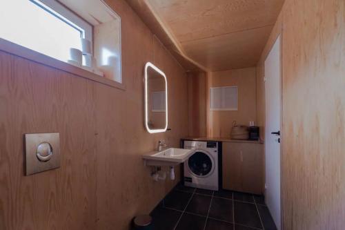 a bathroom with a sink and a washing machine at Fjordview Ryten 2 Retreat in Sund
