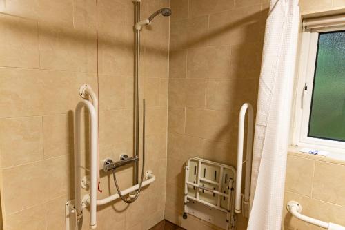 Cliff College في Curbar: كشك للاستحمام في الحمام مع ستارة الدوش