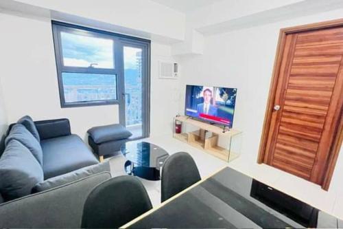 a living room with a couch and a tv at Horizon 101, Condo with a pool & view in Cebu City