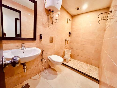 a bathroom with a sink and a toilet and a mirror at The Beach View Resort in Goa