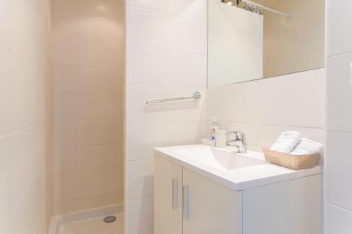 une salle de bain blanche avec un lavabo et une douche dans l'établissement Croisette Beach & Palace, à Cannes